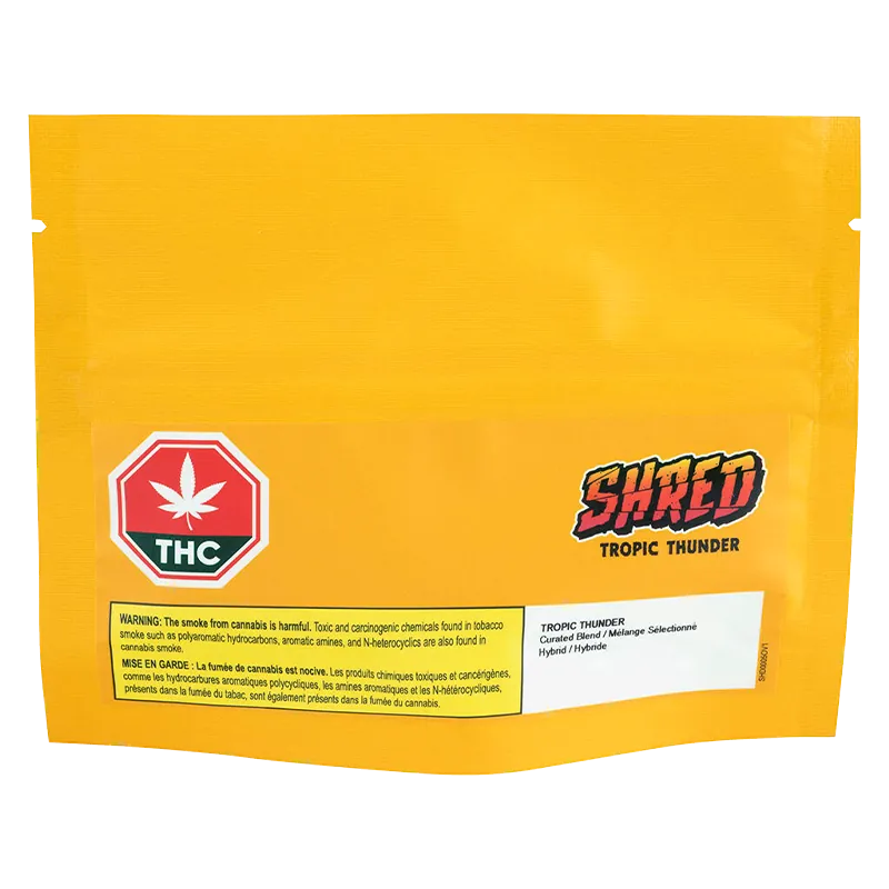 Front-facing shot of the bright yellow pouch labeled "Tropic Thunder" with a red THC emblem and bold "SHRED" logo near the lower-right.