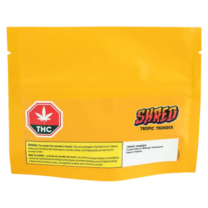 Front-facing shot of the bright yellow pouch labeled "Tropic Thunder" with a red THC emblem and bold "SHRED" logo near the lower-right.