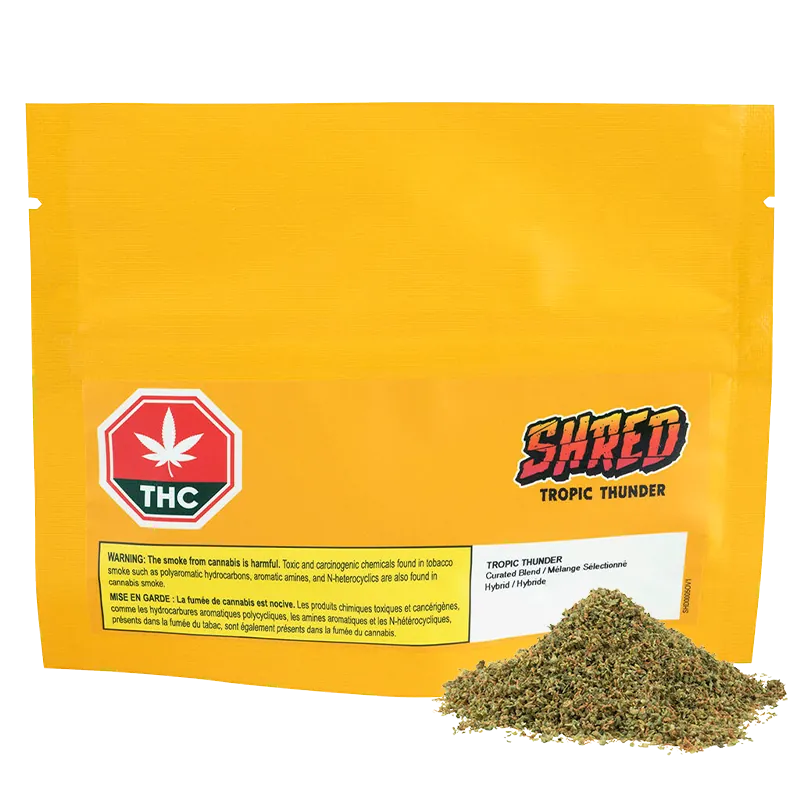 Front-facing yellow pouch with a small pile of loose herb at the lower right and "Tropic Thunder" logo visible on the front.