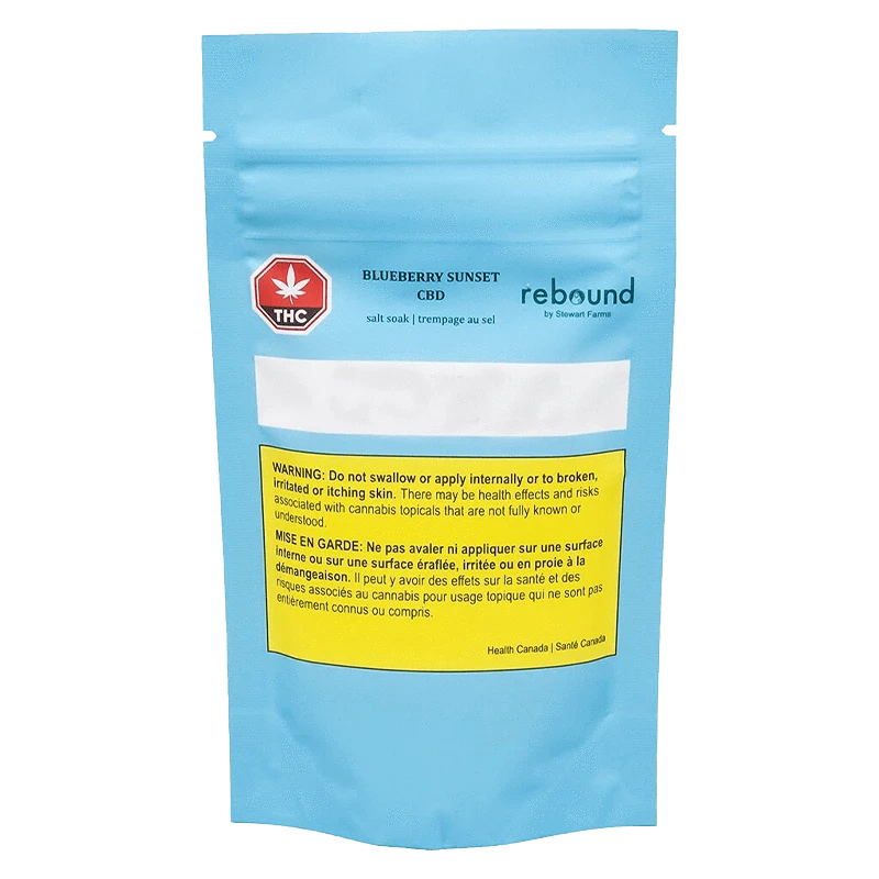 Front-facing shot of a blue pouch labeled Blueberry Sunset CBD salt soak with a yellow warning box and red THC symbol.