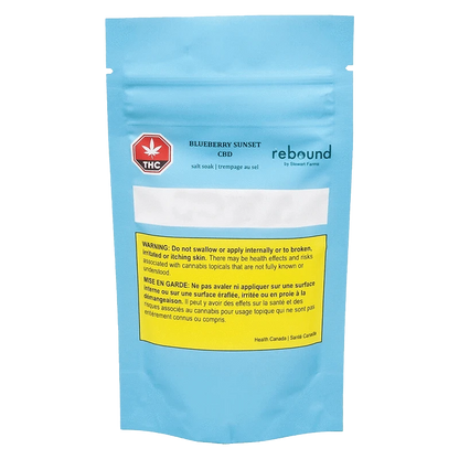 Front-facing shot of a blue pouch labeled Blueberry Sunset CBD salt soak with a yellow warning box and red THC symbol.