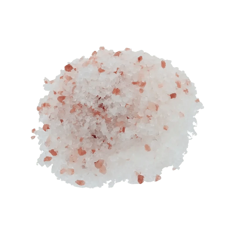 A close-up of the pink Frankinsence Dead Sea Himalayan Bath Salt crystals, scattered on a plain white surface.