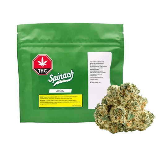 Green resealable pouch labeled "Spinach" with a red THC symbol at left and a bud of Space Cake 28 g placed in front on the right.
