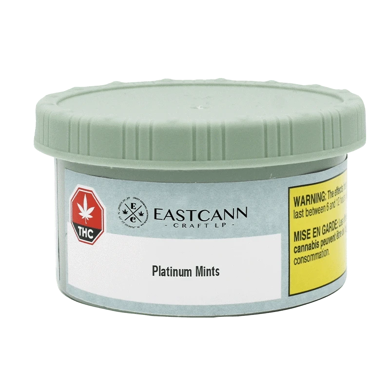 Front view of a low, round tin with a pale green lid showing the EASTCANN - Platinum Mints label and a yellow warning panel.