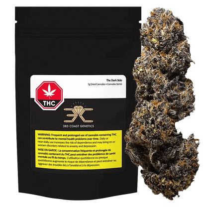 A close-up of “The Dark Side” dried cannabis with a white and green label, appearing as a dense, dark green bud.