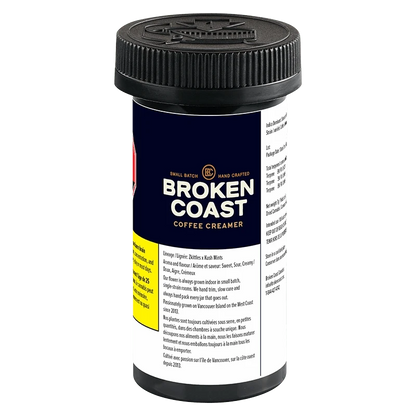 Three-quarter view of the Broken Coast Coffee Creamer black plastic jar with navy label, visible nutrition text and ribbed screw cap.