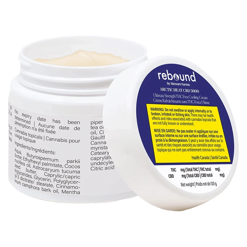 Tilted view of an open jar showing pale cream and the label of Arctic Heat Cbd 5000 Cooling Cream with a blue and yellow warning panel.