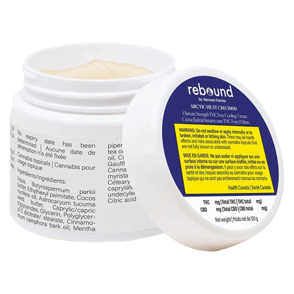 Tilted view of an open jar showing pale cream and the label of Arctic Heat Cbd 5000 Cooling Cream with a blue and yellow warning panel.