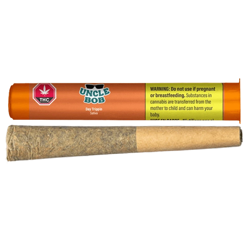 Horizontal studio shot of an orange Uncle Bob Day Trippin PR 1 x 0.5 g tube with a rolled joint placed below it on a white background