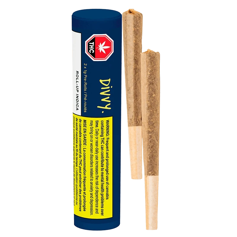 Vertical studio shot of a blue Divvy Roll Up Indica PR 2 x 1 g tube beside two pre-rolled joints on a white background