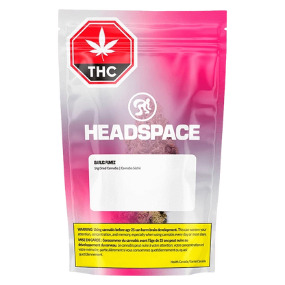 Front-facing shot of the pink-gradient Headspace Garlic Fumez pouch showing a THC warning symbol, white logo, and visible cannabis inside.
