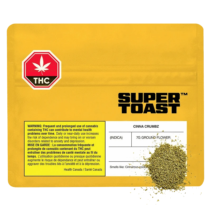 Yellow flat-lay of a resealable pouch labeled Super Toast Cinna Crumbz with a printed THC warning and a small pile of green ground flower at the lower right.