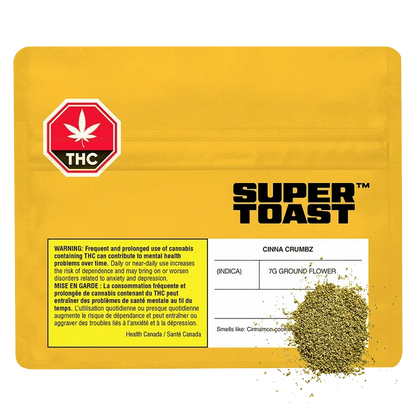 Yellow flat-lay of a resealable pouch labeled Super Toast Cinna Crumbz with a printed THC warning and a small pile of green ground flower at the lower right.