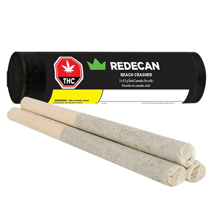 Angled view of three rolled pre-rolls in front of a black tube labeled "REDECAN BEACH CRASHER" with a red THC symbol.
