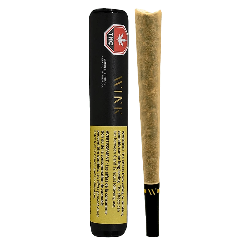 Vertical front view of a Lemon Shortcake Ceramic Tip PR 1 x 2 g pre-roll in black tube packaging beside the unlit joint.