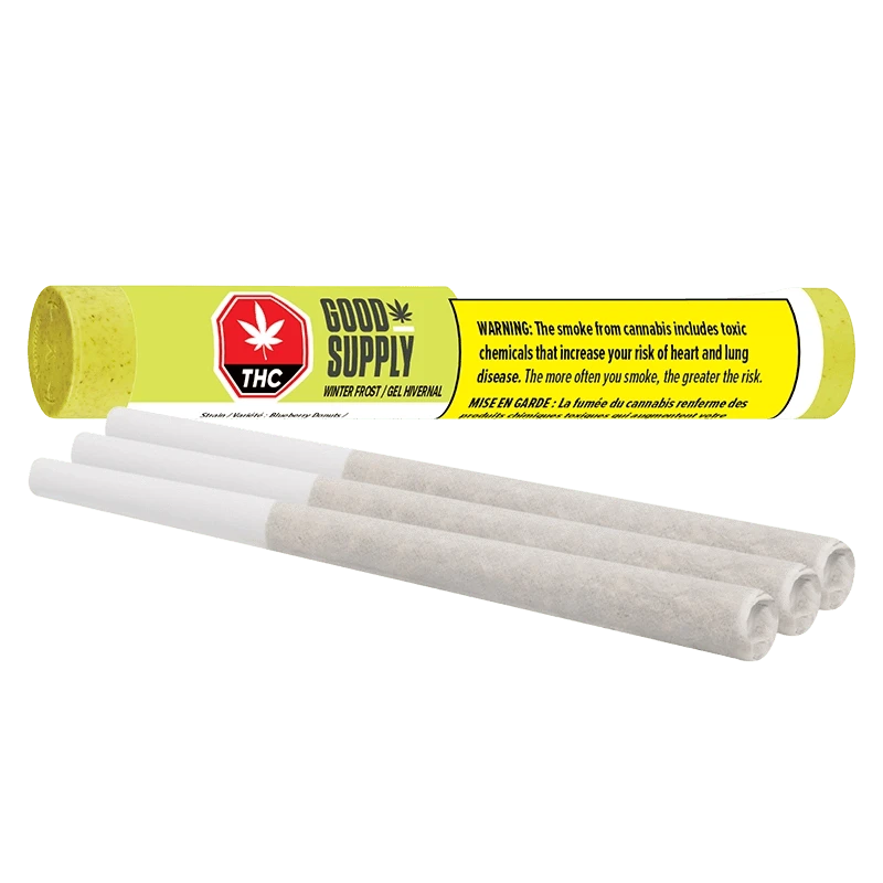 Close-up of three prerolled joints in front of a bright yellow tube labeled Good Supply Winter Frost PR 3 x 0.5 g, shown on a white background.