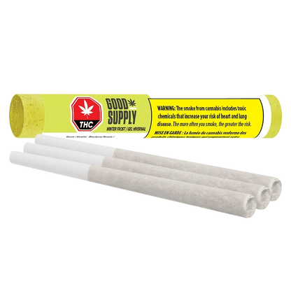 Close-up of three prerolled joints in front of a bright yellow tube labeled Good Supply Winter Frost PR 3 x 0.5 g, shown on a white background.
