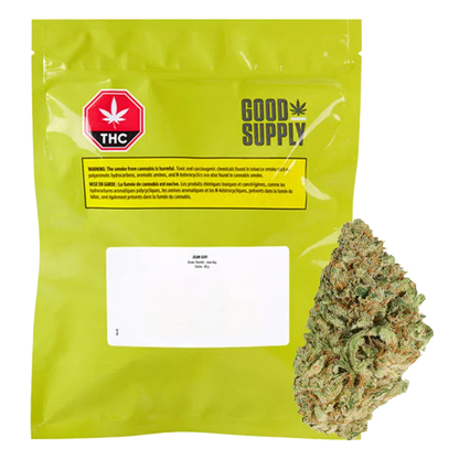 Front-facing shot of the bright green Good Supply Jean Guy pouch with a white label and a single cannabis bud beside it.