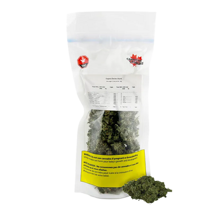 Clear front-facing photo of a sealed bag of Organic Electric Skunk showing green buds through the lower pouch and a yellow warning label.