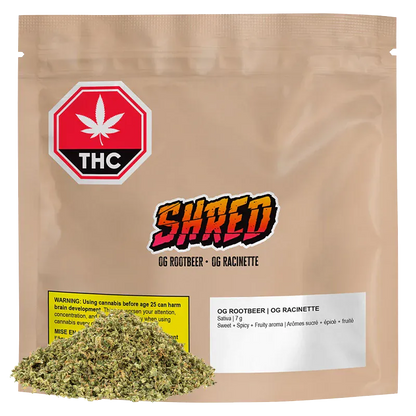 Front view of a tan resealable pouch labeled "OG Rootbeer" with a colorful SHRED logo, THC warning icon, and a small pile of loose dried herb at the base.