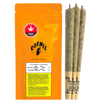 Front-facing shot of the bright orange Carmel Inside Joke PR 3 x 0.5 g pouch standing next to three rolled pre-rolls on a white background.
