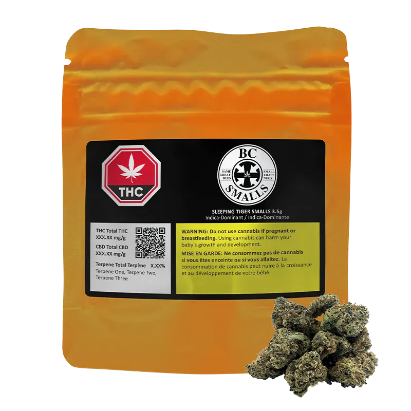 Front-facing shot of a gold pouch with a black label and a small pile of buds in front, showing the Sleeping Tiger Smalls branding.