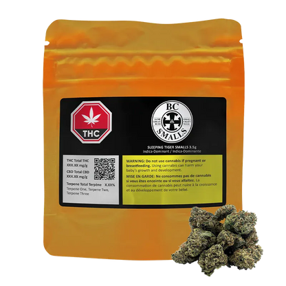 Front-facing shot of a gold pouch with a black label and a small pile of buds in front, showing the Sleeping Tiger Smalls branding.