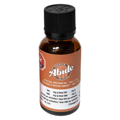 Front-facing shot of the amber bottle labeled "Abide 20:10 Full Spectrum Oil" with a black ribbed cap and a brown-and-white product label.