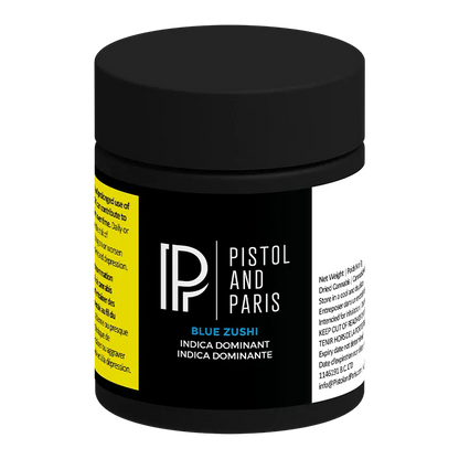 Three-quarter view of a black jar labeled "Pistol and Paris Blue Zushi" with a matte black lid and yellow and white side panels.