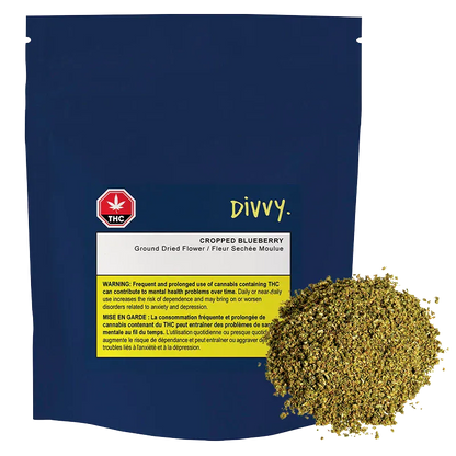 Front-facing pouch of Divvy. Cropped Blueberry with a navy background, white label and a pile of shredded greenish dried flower at the lower right.