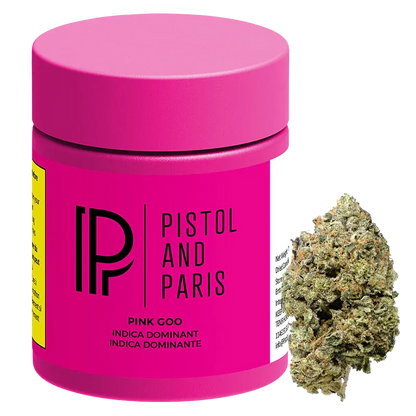 Three-quarter front view of the bright pink Pistol and Paris Pink Goo jar with a cannabis bud positioned to its right.