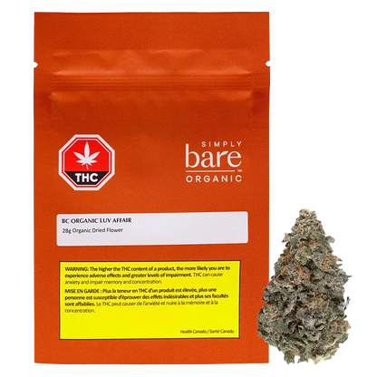 Front-facing shot of the orange pouch and adjacent bud, labeled "BC Organic Luv Affair" with the pouch's white logo and THC warning visible.