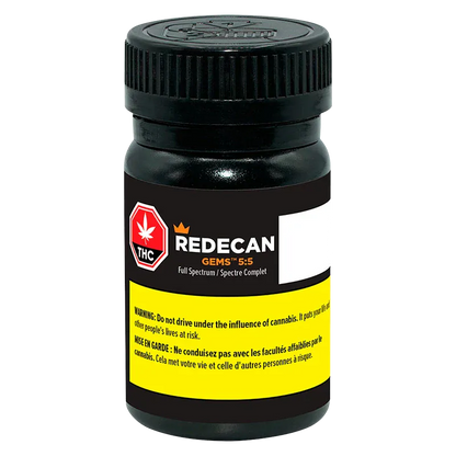Front view of a black pill-style jar labeled Redecan Gems 5:5 with a yellow warning band and a red THC icon.