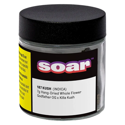 Front three-quarter view of a clear jar labeled "soar 187 Kush" with a black lid, black-and-yellow label and white product text.