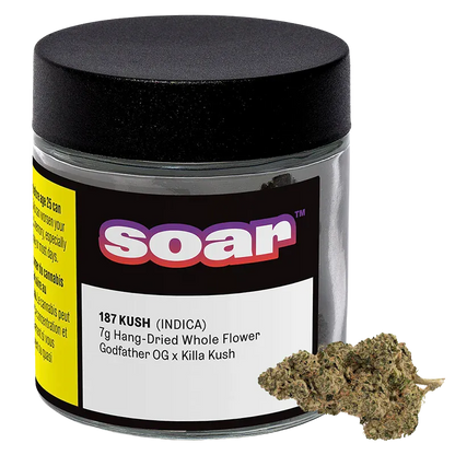 Front three-quarter view of a clear jar with a black lid labeled "soar 187 Kush" and a small pile of dried flower at its base.