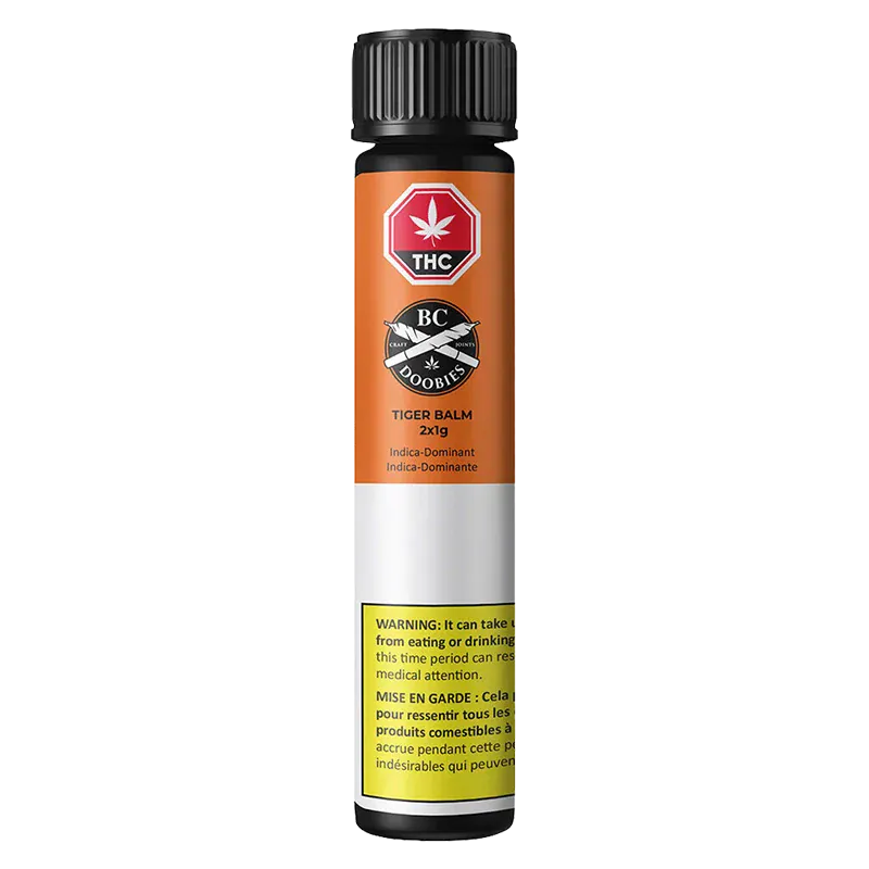 Straight-on view of the Tiger Balm PR 2 x 1 g tube with orange label, black cap, and a yellow warning block near the base.