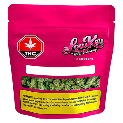 Front-facing pouch of Cookie'z by LowKey showing a bright magenta package with a THC symbol and a clear window revealing green cannabis buds.