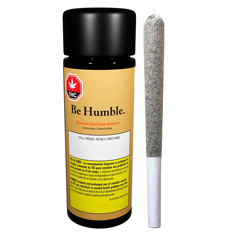 Front-facing shot of a black-capped jar labeled "Be Humble. Glazed Apricot Gelato PR 5 x 0.5 g" standing next to a single pre-rolled joint on a white background.