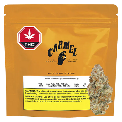 Front-facing shot of the golden pouch labeled "Carmel Astronaut Status" with a THC symbol at top left and a cannabis bud image overlapping the lower right.