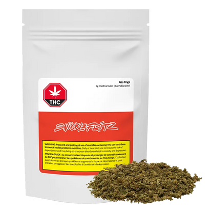 Front-facing shot of a white pouch labeled Gas Tingz with a red band and a pile of green-brown dried herb at its base.