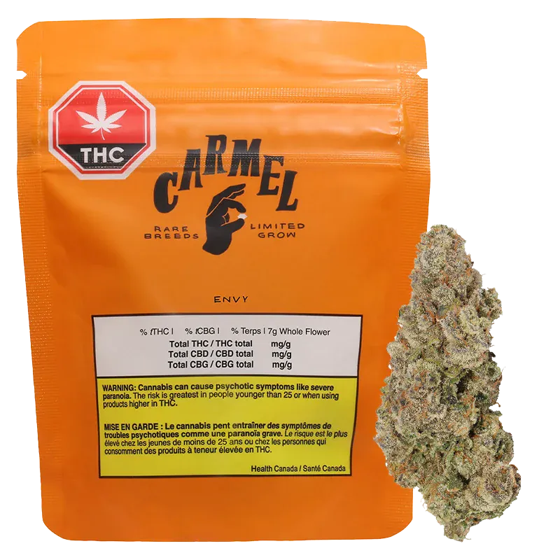 Front view of the orange Carmel Envy pouch with THC label, showing printed nutrition box and a cannabis bud beside it.