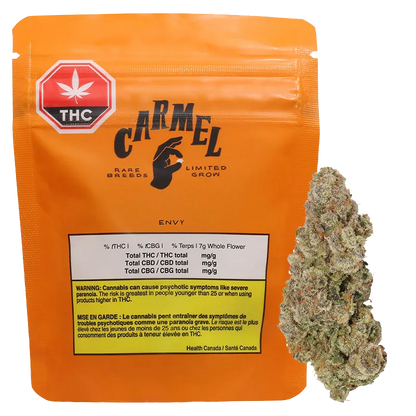 Front view of the orange Carmel Envy pouch with THC label, showing printed nutrition box and a cannabis bud beside it.