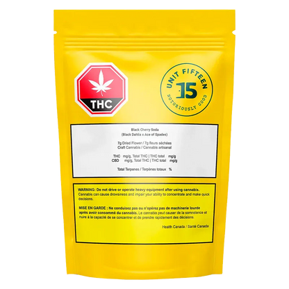 Rear view of the yellow pouch showing the Unit Fifteen U15 Black Cherry Soda Sativa 7 g - Unit 15 logo, THC stop sign, and warning labels.
