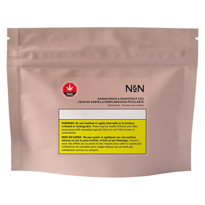 Front-facing shot of the N&N Sandalwood & Grapefruit Fizz Bath Bomb resealable blush pouch with a centered label and yellow THC warning block.