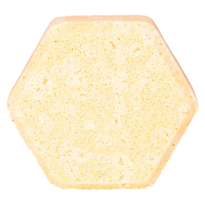 Top-down view of a pale yellow hexagonal Sandalwood & Grapefruit Fizz Bath Bomb against a white background.