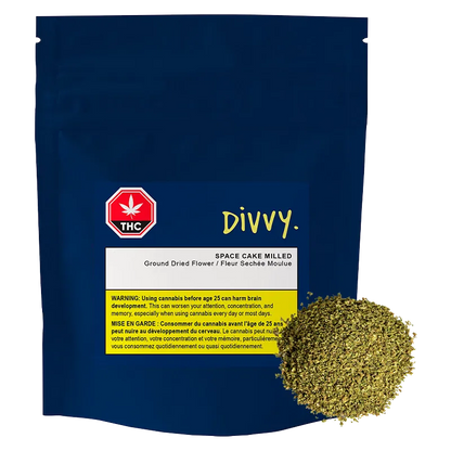 Front view of the navy pouch labeled "DIVVY. SPACE CAKE MILLED" with a white and yellow warning panel and a mound of milled herb at the lower right.