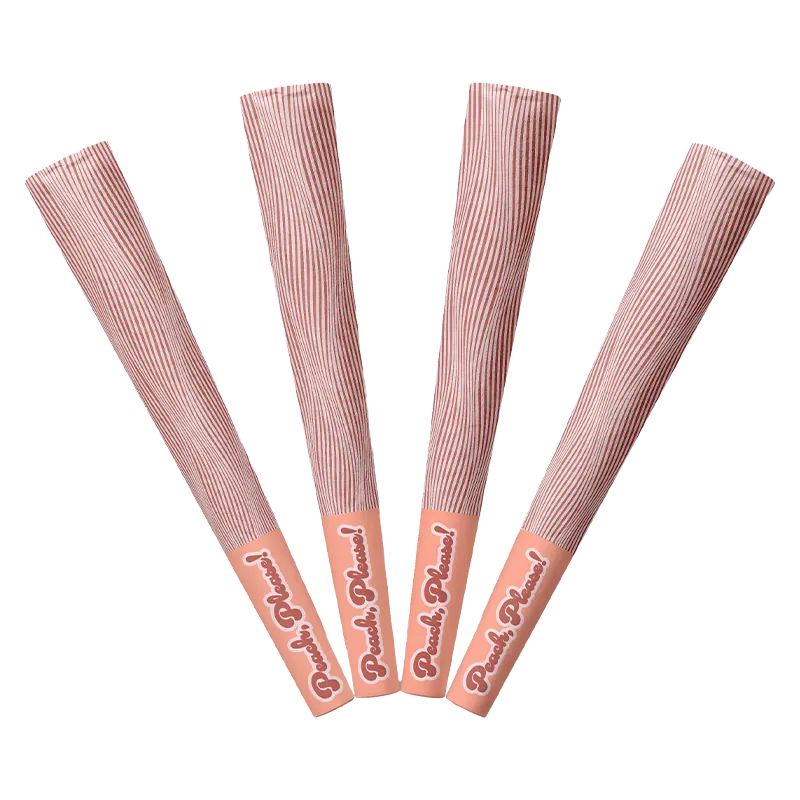Top-down view of four peach-toned Peach Please PR 4 x 0.5 g sticks fanned out with striped wrappers and branded caps.
