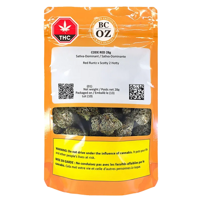 Front-facing shot of the orange BC OZ Code Red pouch showing a clear window of green cannabis buds and warning labels.