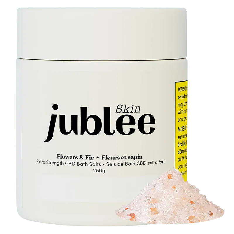 Front-facing jar of Jubilee Skin Flowers & Fir Extra Strength CBD Bath Salts with a small pile of pink bath salt in the foreground.