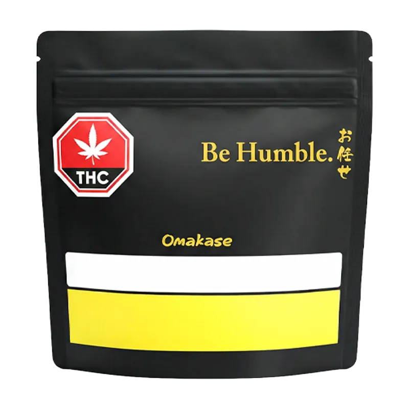 Front-facing shot of the black pouch labeled "Omakase" with gold "Be Humble." text and a red THC symbol.